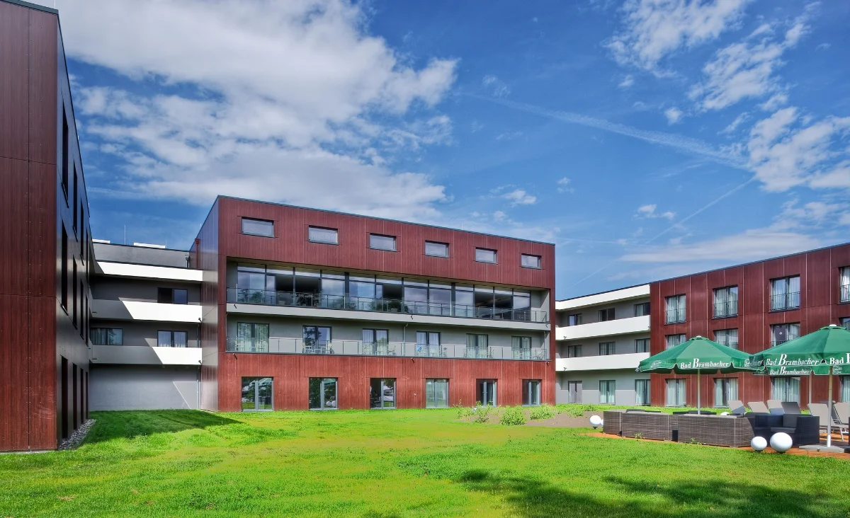 Außenansicht eines Gebäudes mit einem gepflegten Rasen und grünem Gras.