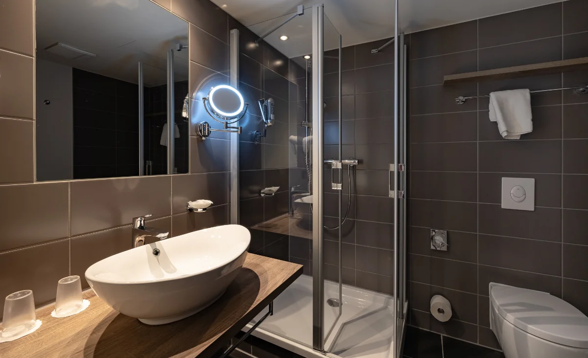 Badezimmer mit Waschbecken, Toilette und Dusche in einem modernen Design