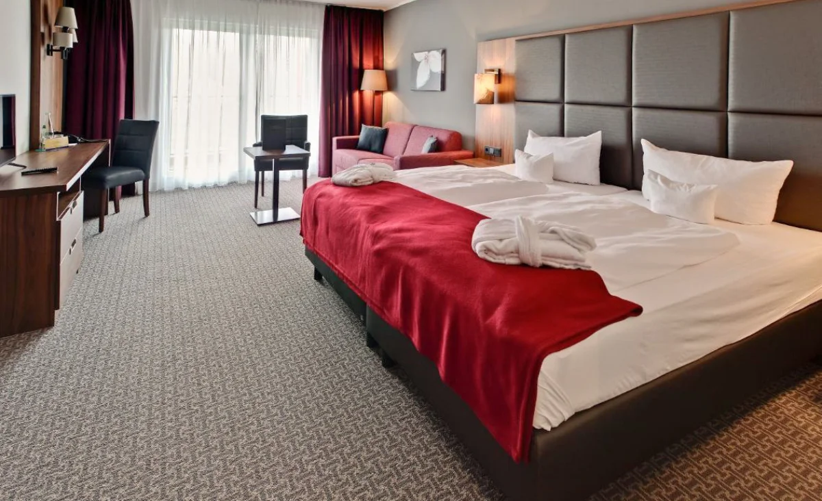 Gemütliches Hotelzimmer mit einem großen Bett und einem Fernseher auf einem Tisch.