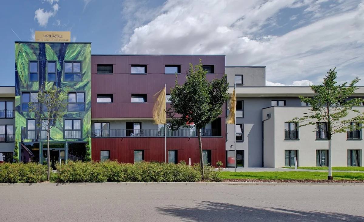 Ein Gebäude aus buntem Glas mit einem begrünten Dach.