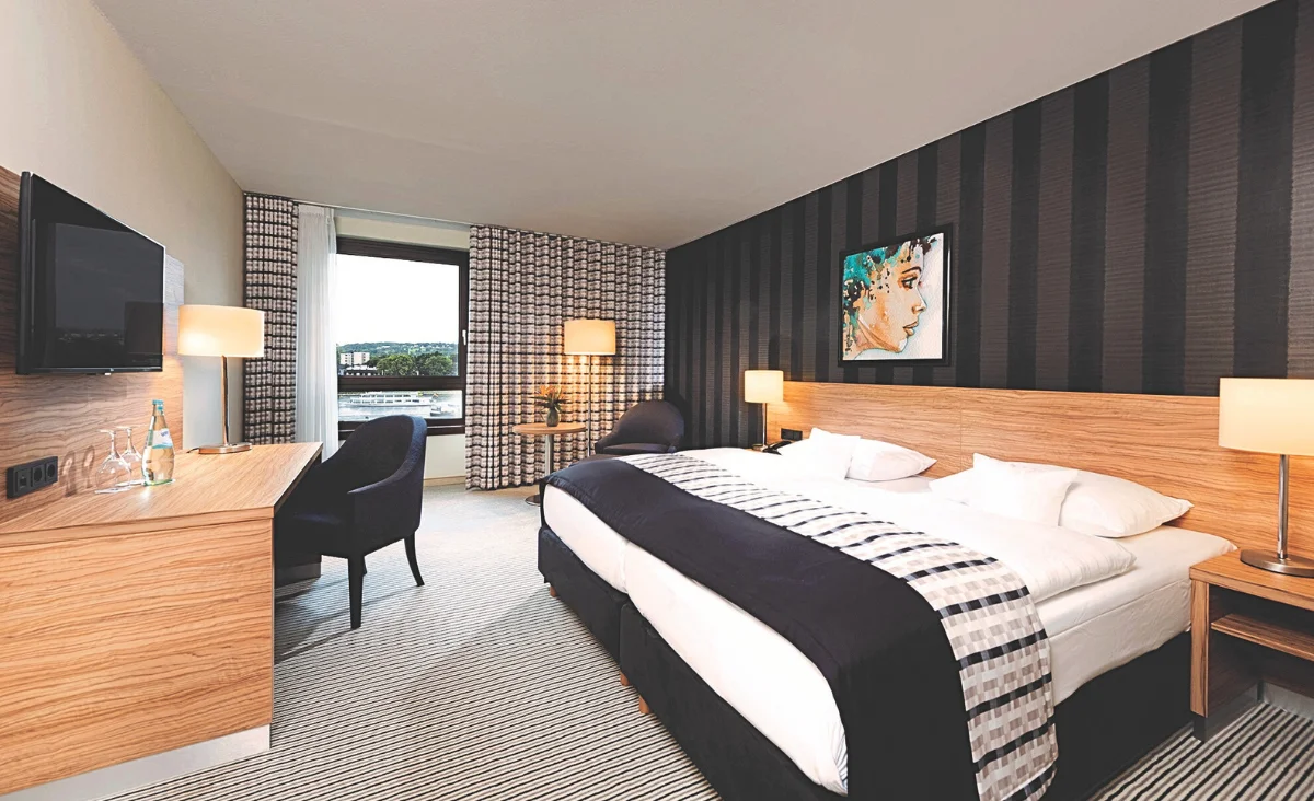 Gemütliches Hotelzimmer im 4* Maritim Hotel Königswinter, ausgestattet mit Bett, Schreibtisch und Fernseher.