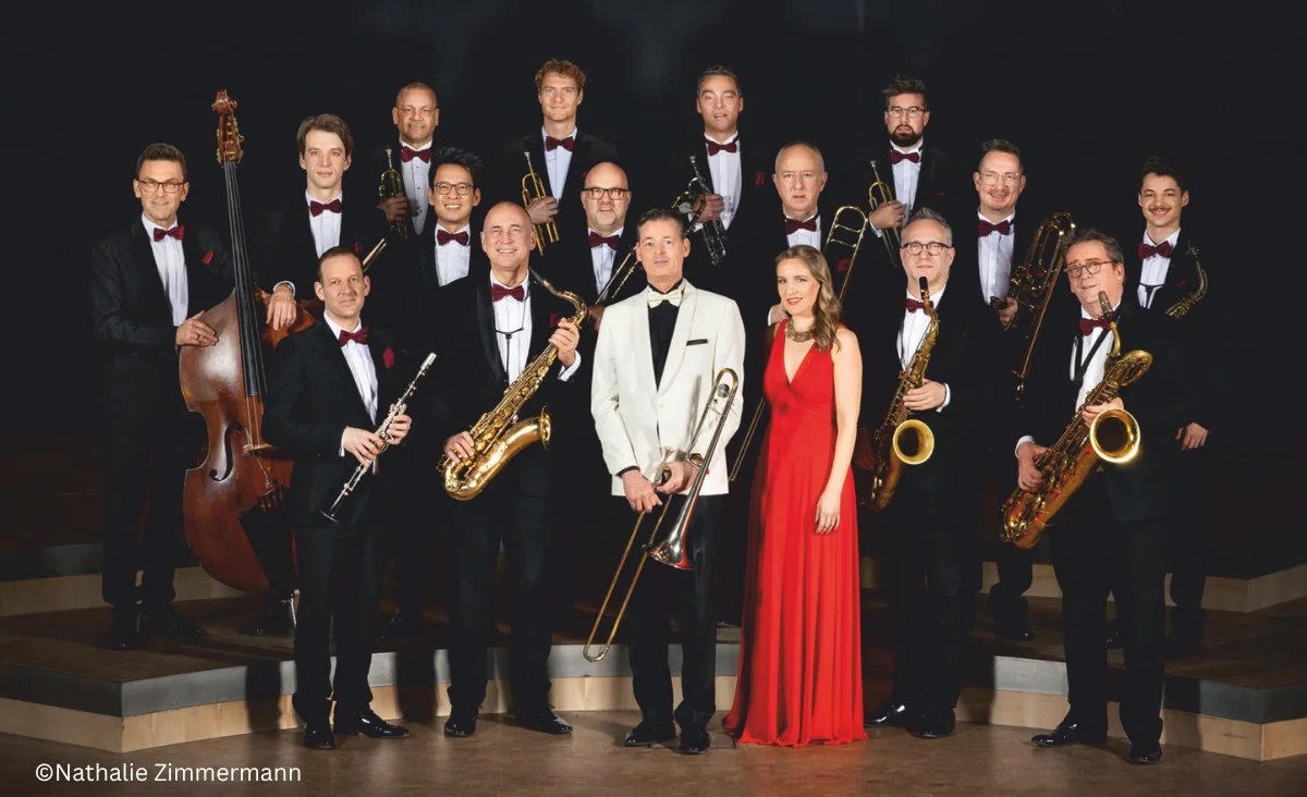 Das Orchester posiert mit seinen Instrumenten für ein Foto, inspiriert von Glenn Miller.