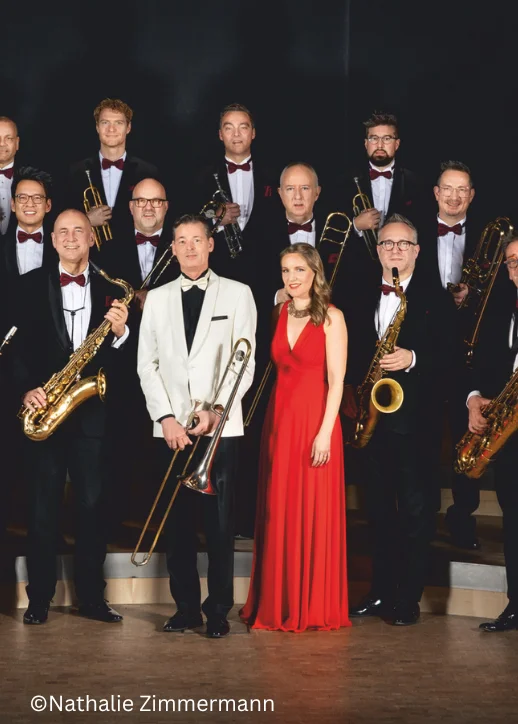 Das Orchester posiert mit seinen Instrumenten für ein Foto, inspiriert von Glenn Miller.