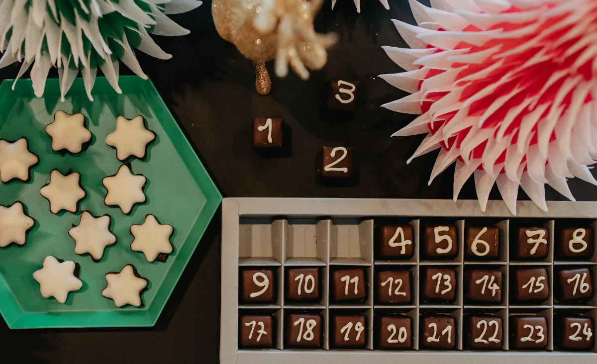 Ein Tisch mit schokoladigen und sternförmigen Keksen, ideal für die Adventszeit und als Geschenk von Walter Confiserie.