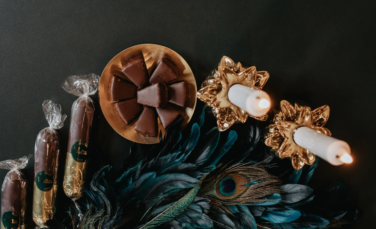 Ein Wreath aus Schokolade und Süßigkeiten, geschmückt mit einer Kerze, symbolisiert festliche Adventsfreude von Walter Confiserie.