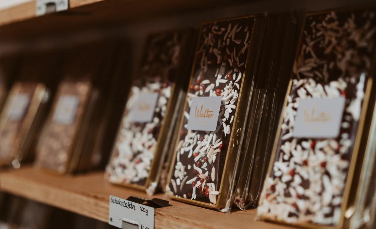 Schokoladenriegel in einer Auslage der Walter Confiserie in Berlin, umgeben von festlicher Adventsdekoration.