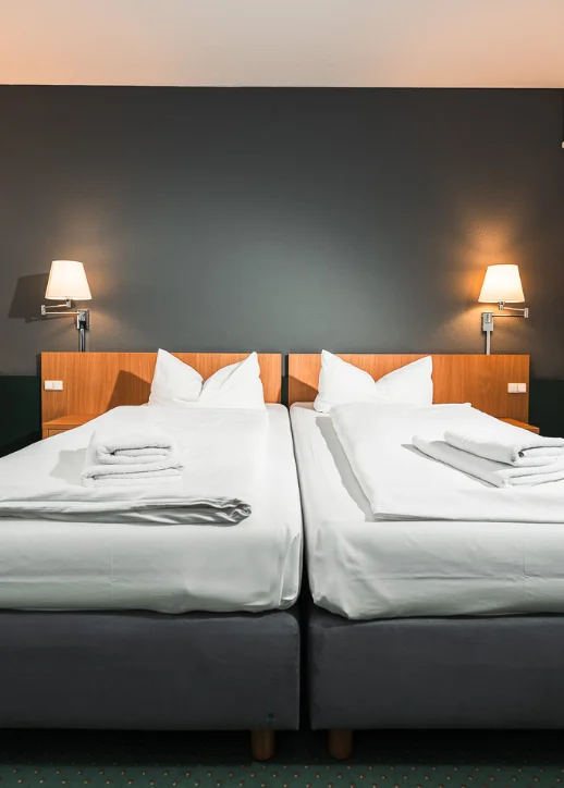 Zwei Betten in einem gemütlichen Zimmer im Martas Hotel Lutherstadt Wittenberg.