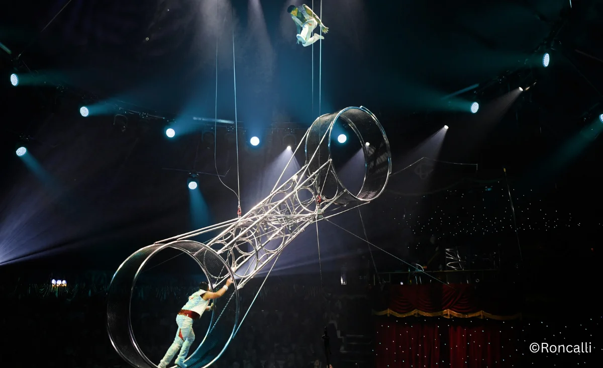 Zwei Menschen im Zirkusring, die einen Reifen im Roncalli Weihnachtscircus in Berlin verwenden.
