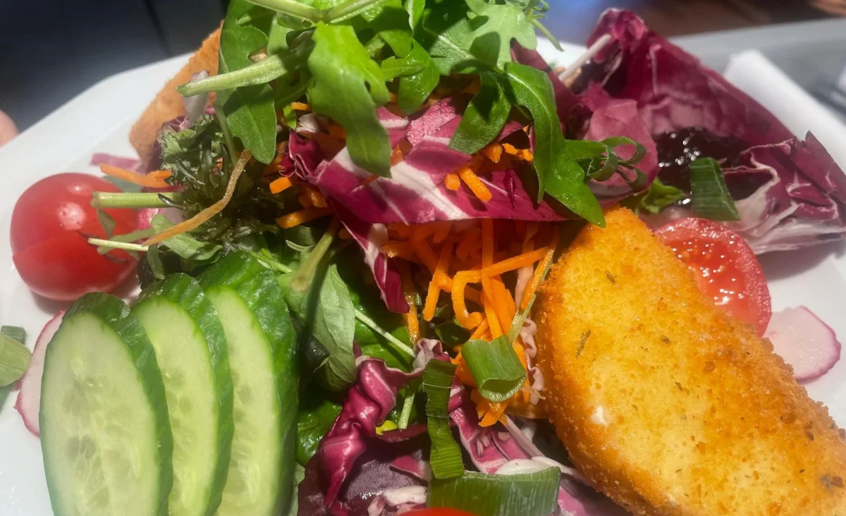 Salat mit Radicchio, Rucola, Karottenstreifen, Gurkenscheiben, Kirschtomaten und paniertem, gebratenem Käse.Restaurant Machiavelli am Roseneck