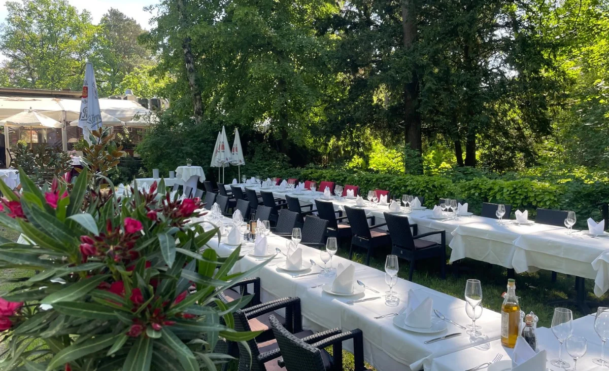 Langer Tisch im Restaurant Machiavelli am Roseneck, vorbereitet für eine Dinner-Party mit dekorativen Elementen und Geschirr.
