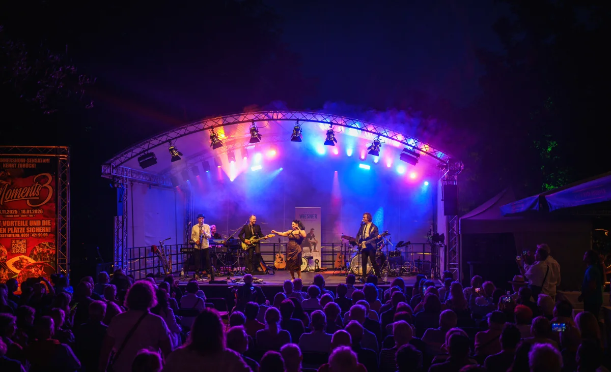 Eine Band spielt nachts auf der Bühne vor einer begeisterten Menge beim Dresdner Schlößernacht-Festival.