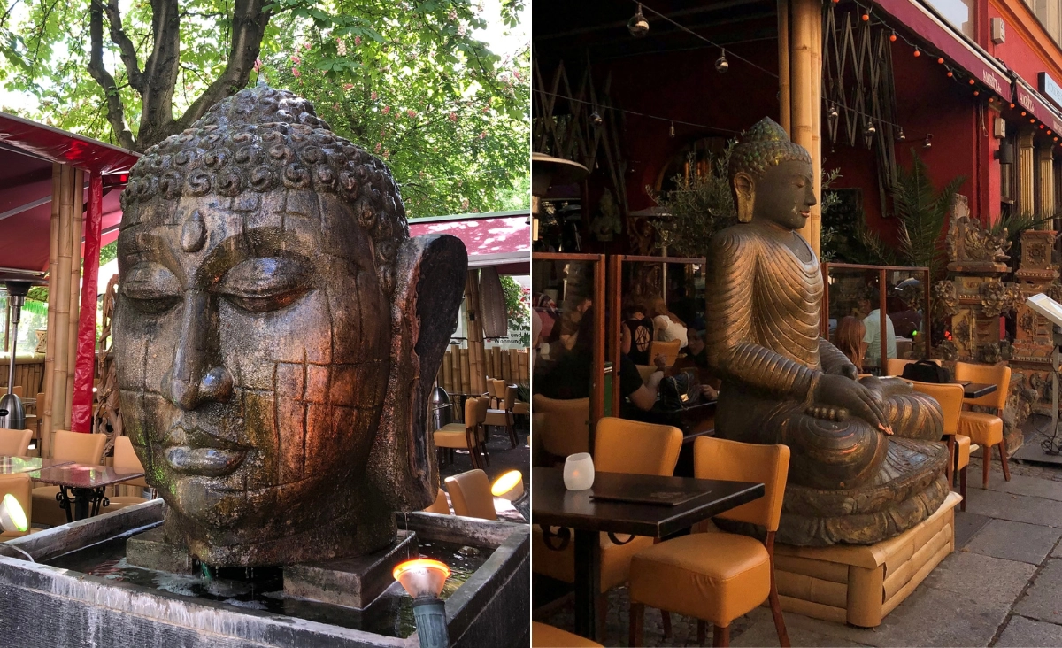 Links eine große Buddha-Kopf-Skulptur mit geschlossenen Augen vor Bäumen und roten Sonnenschirmen, rechts eine sitzende Buddha-Statue neben Tischen und Stühlen vor einem Restaurant.