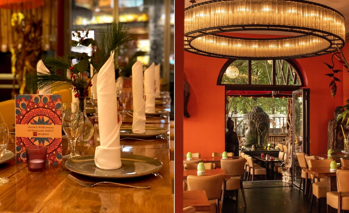 Gedeckter Holztisch mit aufrecht gefalteten weißen Servietten, Glasvasen mit Pflanzen und einem bunten Wertgutschein von AMRIT Restaurants, rechts stilvoll eingerichteter Gastraum mit rundem Kronleuchter.