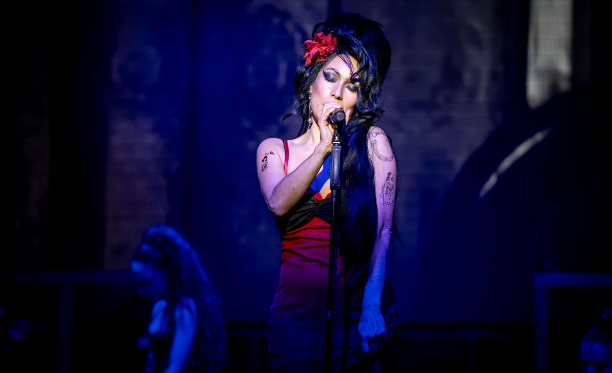 Sängerin mit hochgestecktem Haar und schwarzem Kleid hält Mikrofon auf einer Bühne vor Publikum bei einer Amy-Winehouse-Tribute-Show im Estrel Showtheater Berlin.