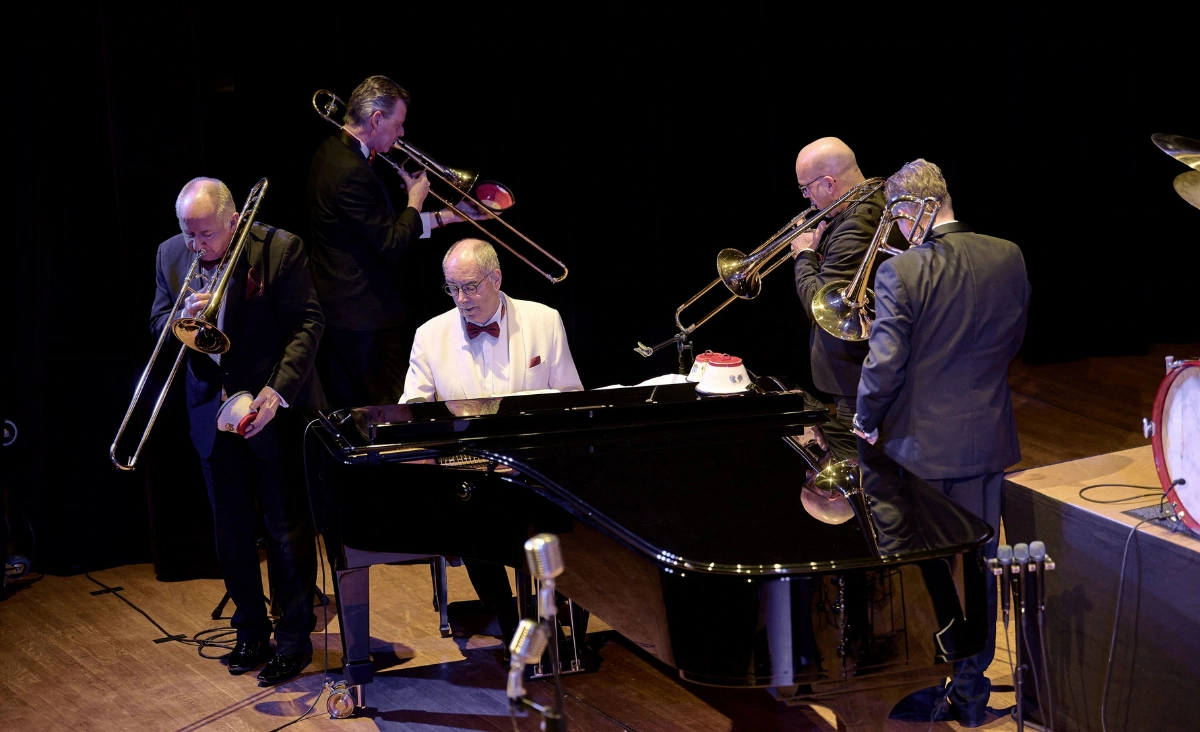 Glenn Miller Orchestra Musiker mit Posaunen um einen Pianisten am Flügel auf der Bühne
