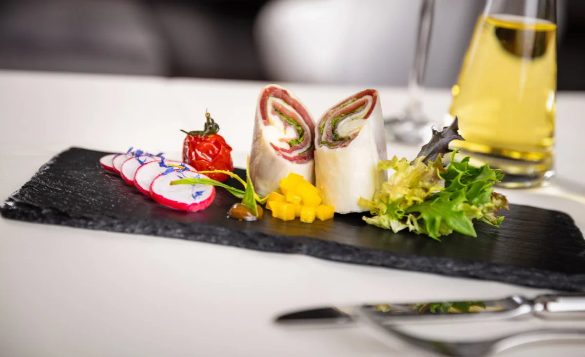 Exquisit angerichtete Vorspeise im Hotel Bodenmaiser Hof auf Schieferplatte mit Schinken-Röllchen und frischen Zutaten